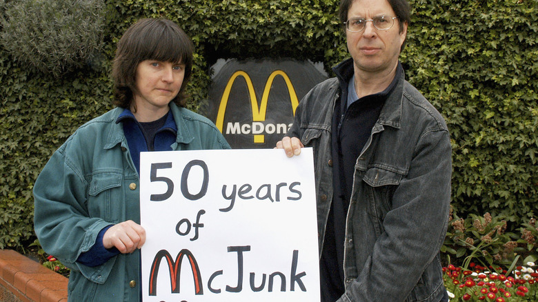 Anti McDonald's campaigners, Helen Steel and Dave Morris with a protest sign that reads "50 years of mcjunk"