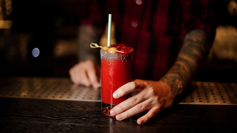 Bartender holding Bloody Mary glass
