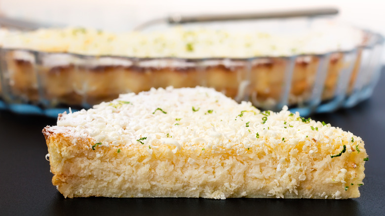 a slice of impossible pie with the rest of the pie in a glass dish behind it