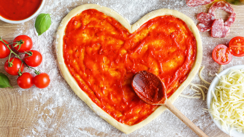 heart-shaped pizza with sauce