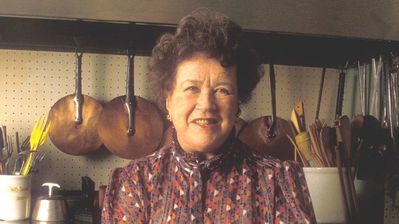 Julia Child stands in a kitchen.