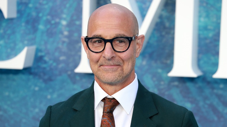 Stanley Tucci in glasses with suit and tie