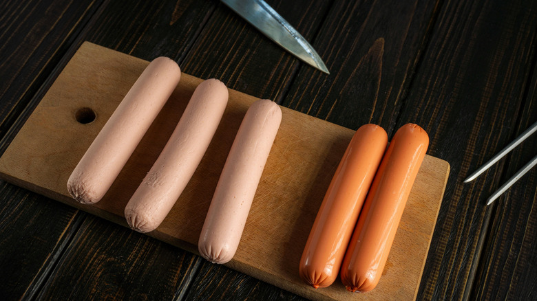 hot dogs on a cutting board with a knife