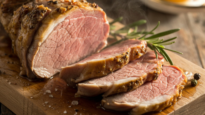 Sliced pork tenderloin wooden board.