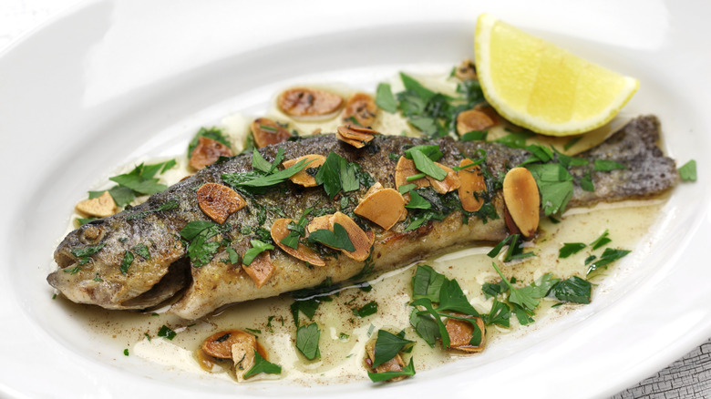 trout almondine with lemon wedge