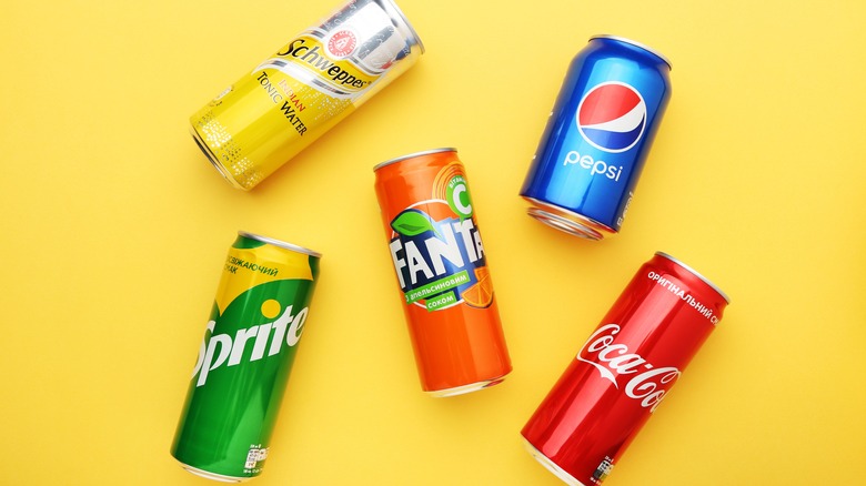 Cans of soda on a yellow background