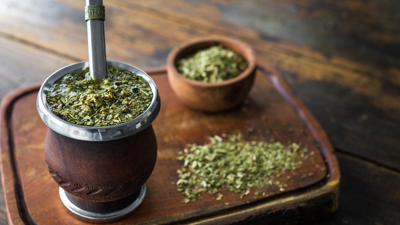 Mate in traditional gourd cup with yerba mate leaves