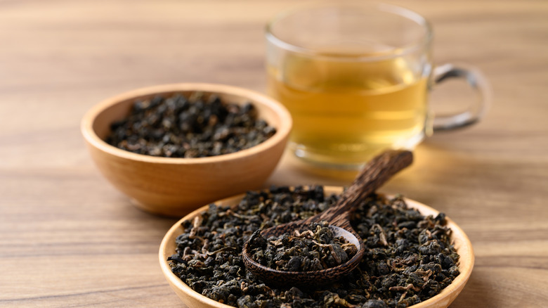 Dried oolong tea leaves and cup of tea