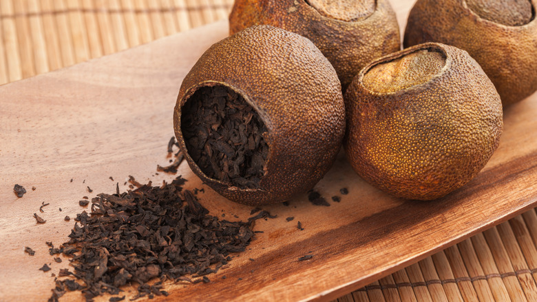 Pu-ehr tea packed in dried mandarins spilling onto table
