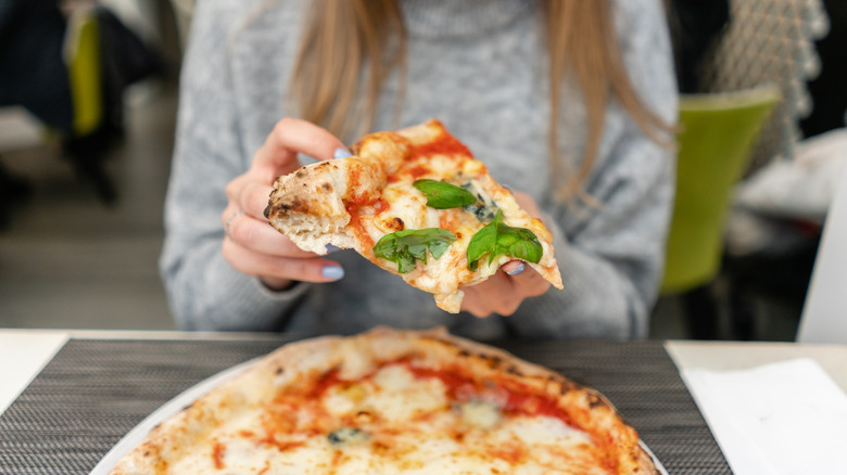 Person eating Neapolitan pizza