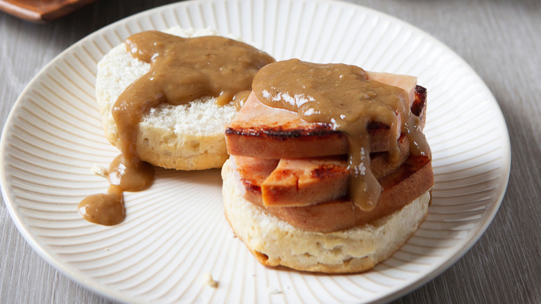 Biscuit stacked with slices of fried ham and topped with red-eye gravy