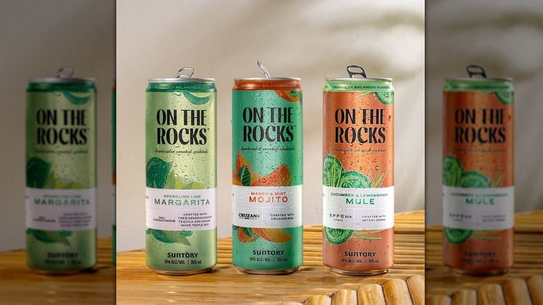 Canned On the Rocks cocktails on wooden surface