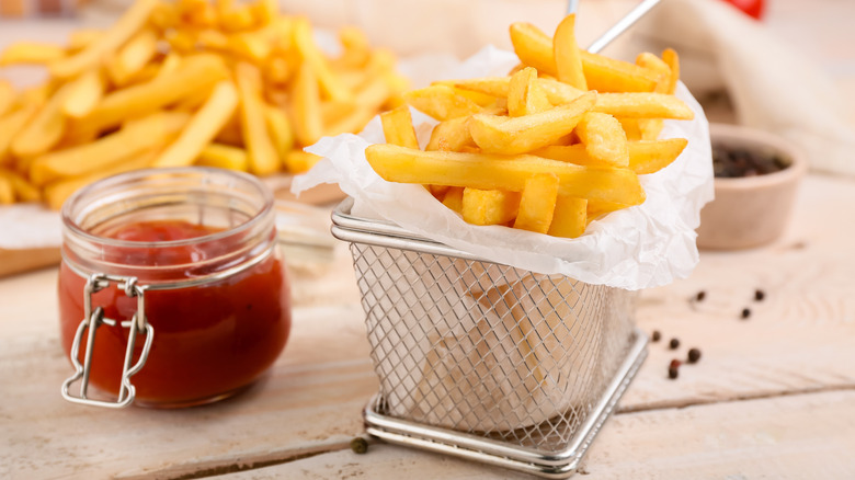 basket of french fries with jar of ketchup