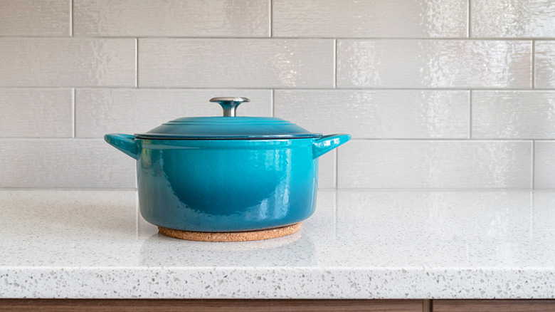 Blue pot on a granite countertop, placed on a hot pad