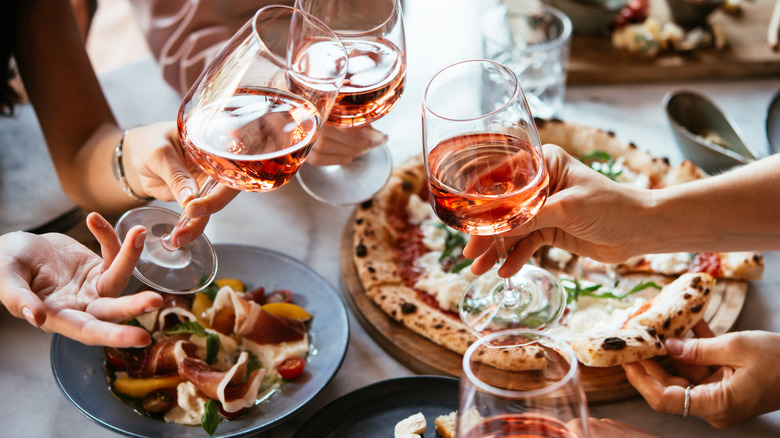 glasses of rose wine over pizza and a lunch spread