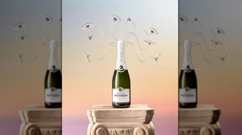 A Taittinger bottle sits atop a Grecian column with various Medusa-like antenna disk wires coming off the top