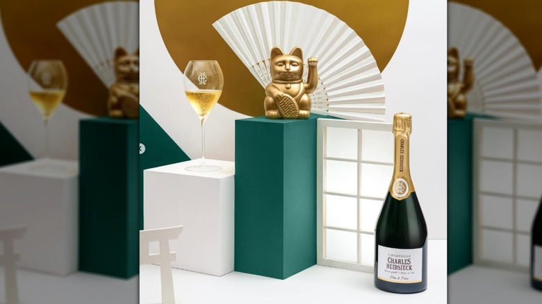 A bottle of Charles Heidsieck sits next to art structures and decor reminiscent of China