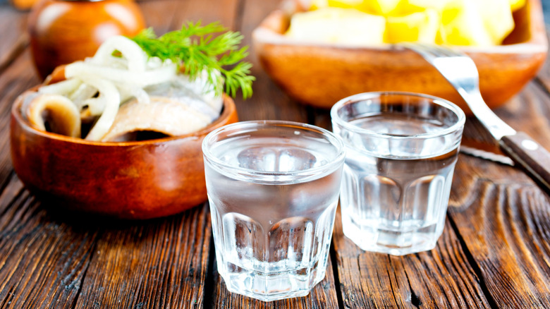 Two small glasses of vodka on a wooden table