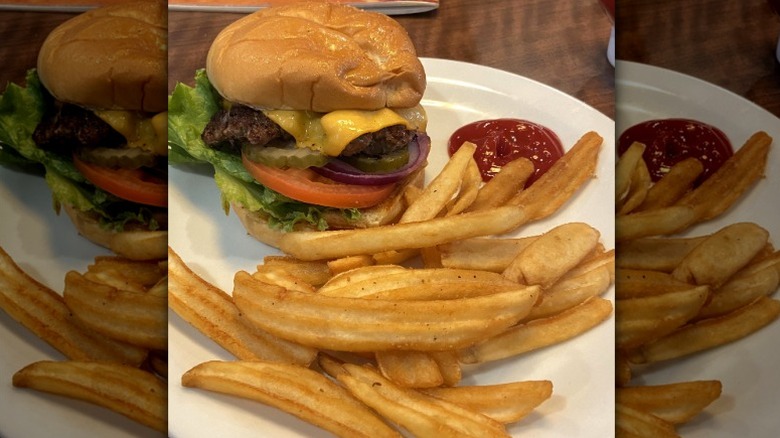 Denny's cheeseburger with pickles, onion, and wavy fries