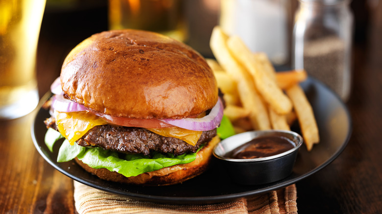 Cheeseburger and french fries on a black plate