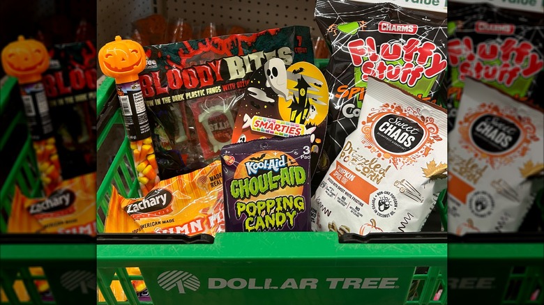 Green Dollar Tree branded basket of Halloween candy products including cotton candy and candy corn