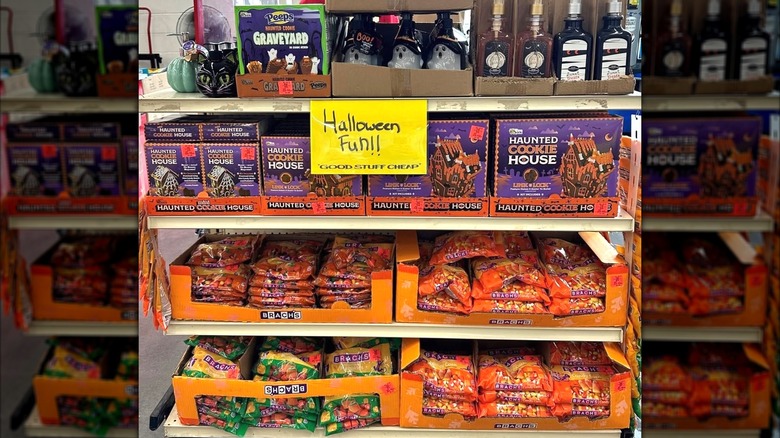 Shelves of Halloween items inside Ollie's Outlet store, including candy corn bags and Halloween cookie house kits