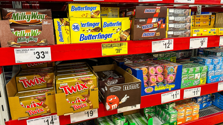 Shelves of candy boxes in Sam's Club store including Milky Way, Butterfinger, and M&M's