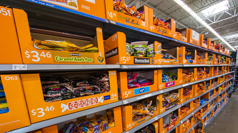 Shelves of Halloween candy in orange cardboard boxes inside Walmart store