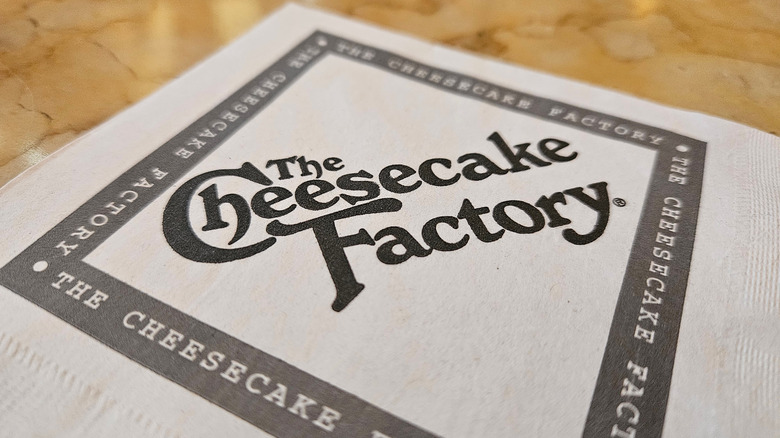 person holding Cheesecake Factory menu