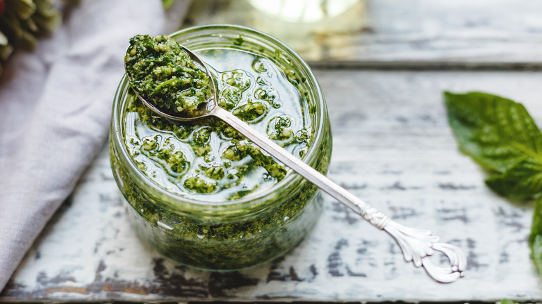 Jar of pesto on a wooden table 