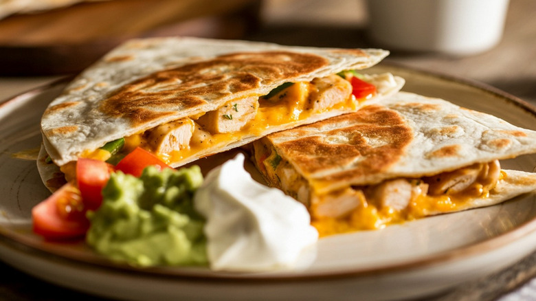 Cheesy Quesadilla on a Plate with Sour Cream and Guacamole