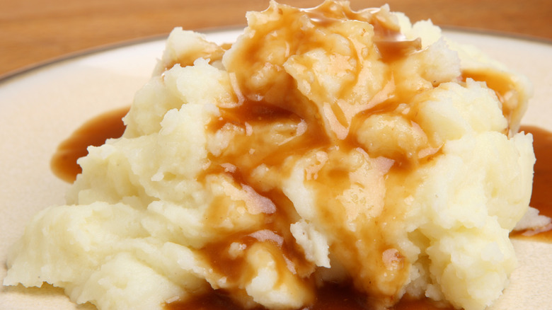Mashed potatoes with gravy poured over.