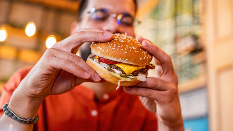 man eating cheeseburger