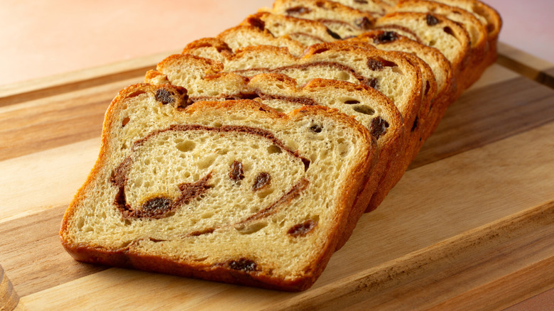 Stack of cinnamon raisin bread on a wooden cutting board