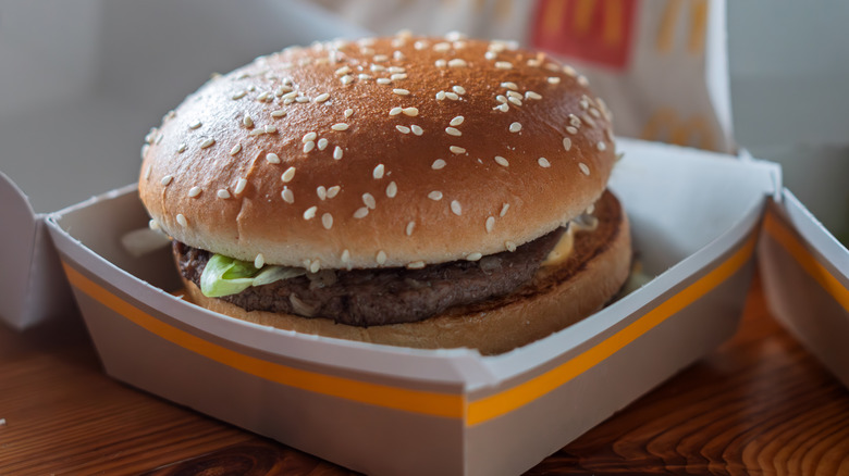 McDonald's burger in its cardboard carton on a wooden table