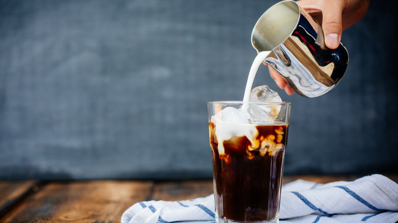 Pouring milk in iced latte