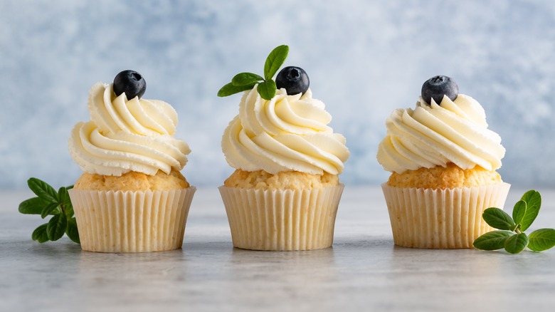 cupcakes with frosting and blueberry garnish