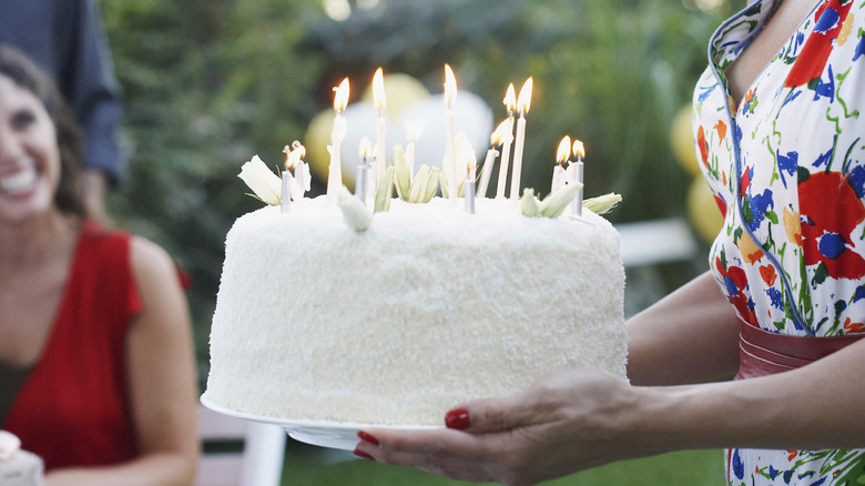 carrying birthday cake with candles