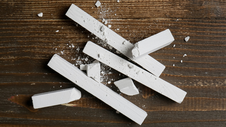 Sticks of white chalk with crumbles of chalk around them