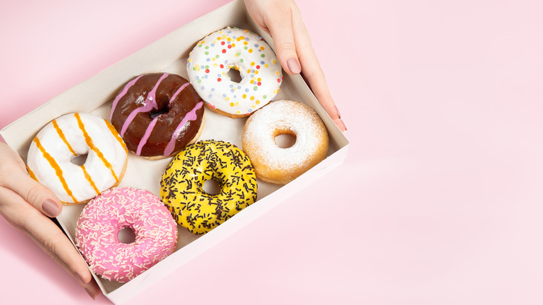 box of donuts against pink background