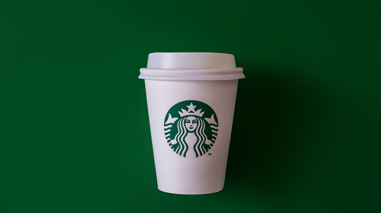 Starbucks coffee cup on green background