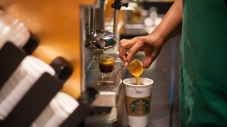 worker pouring espresso at Starbucks