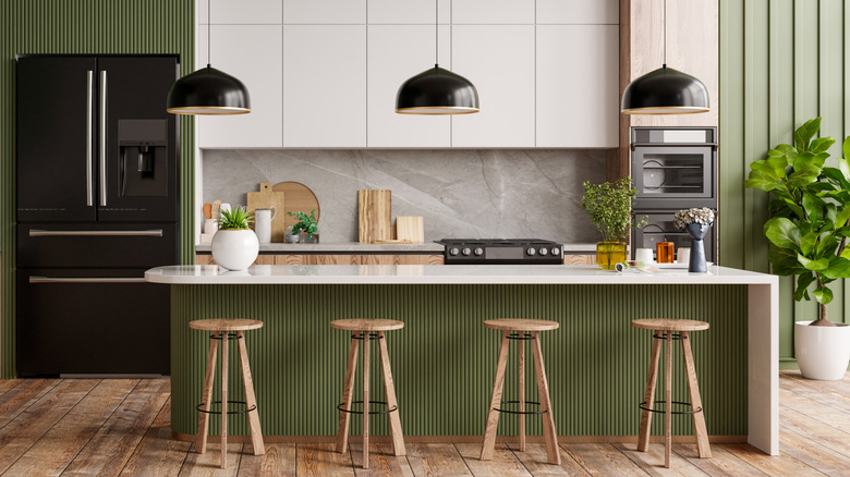 View of a modern kitchen with green accent walls and kitchen island