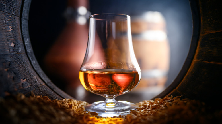 Whiskey in a tasting glass inside an againg barrel
