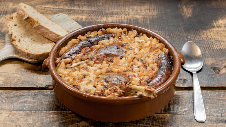 Cassoulet French stew in bowl with bread, spoon