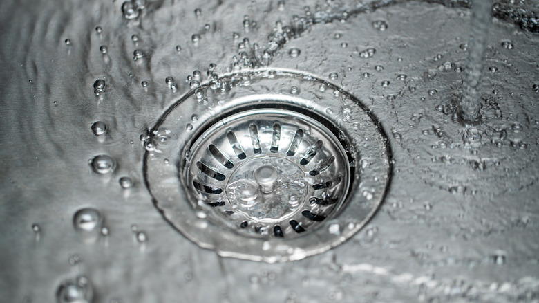 Kitchen sink drain close-up with pouring water