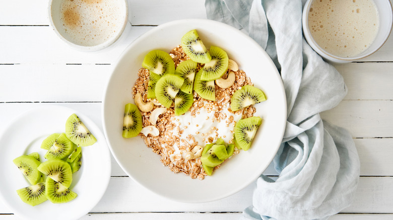 Bowl of granola topped with kiwi pieces