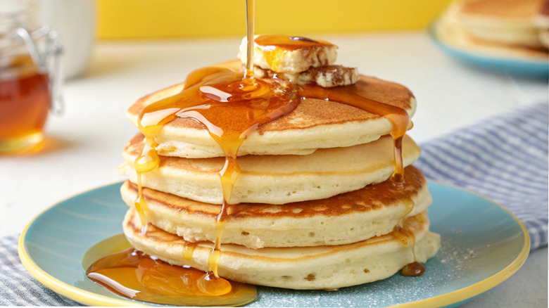 Buttermilk pancakes stacked on a plate with syrup