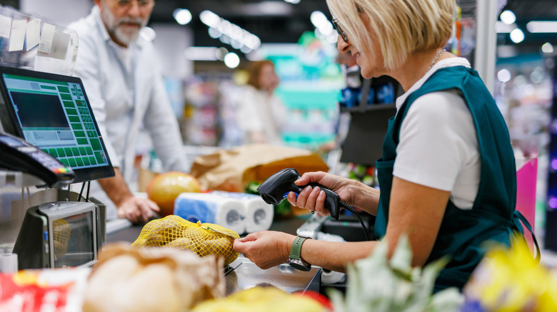 Cashier scans item at a grocery store checkout