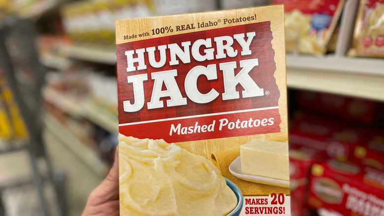 A hand holds box of Hungry Jack mashed potatoes
